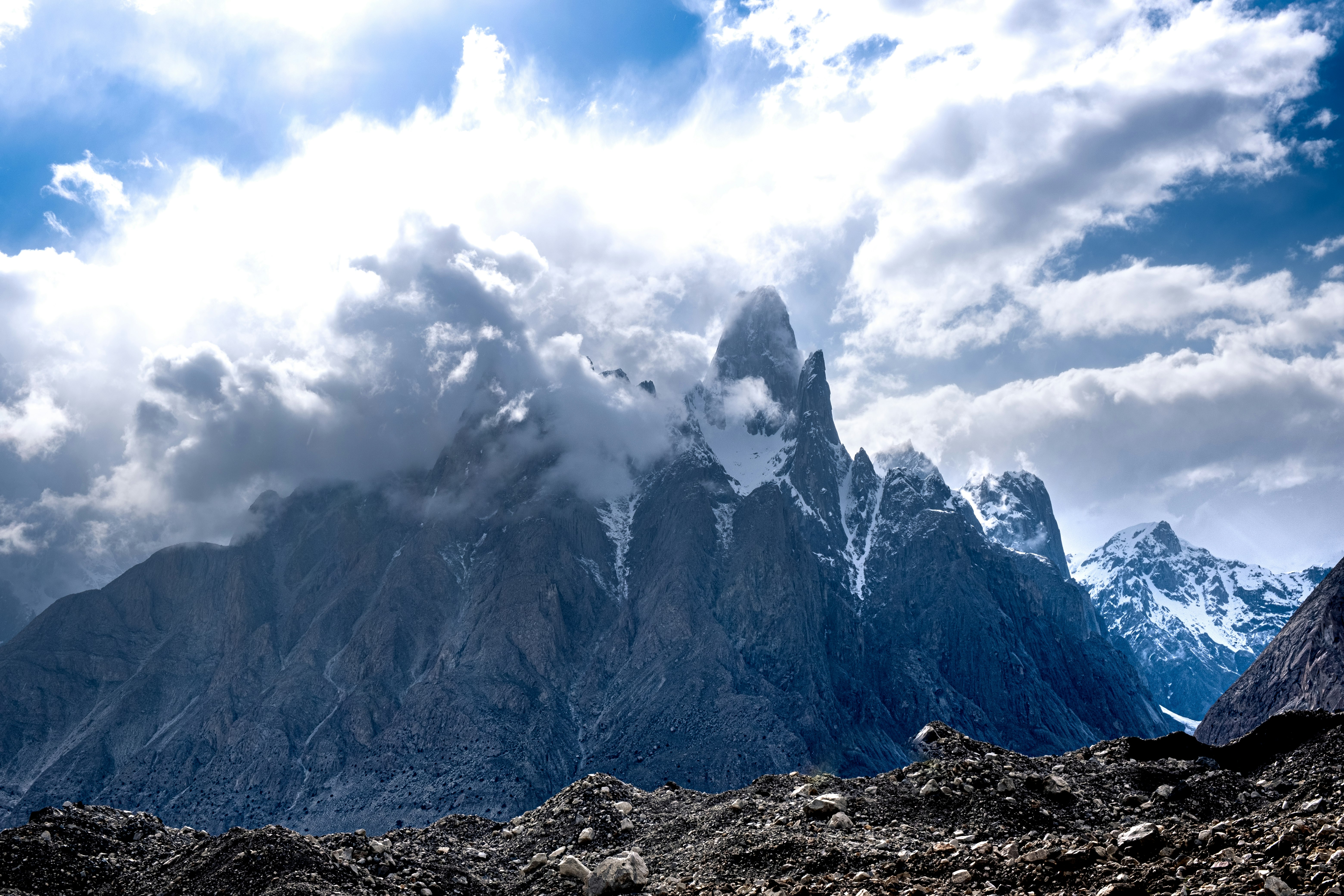 snow covered mountain under white clouds during daytime